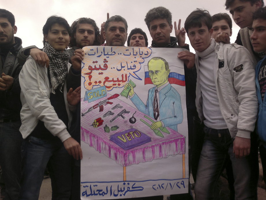 Demonstrators hold a sign as they gather during a protest against Syria's President Bashar al-Assad and Russia in Kafranbel, near Idlib January 29, 2012.