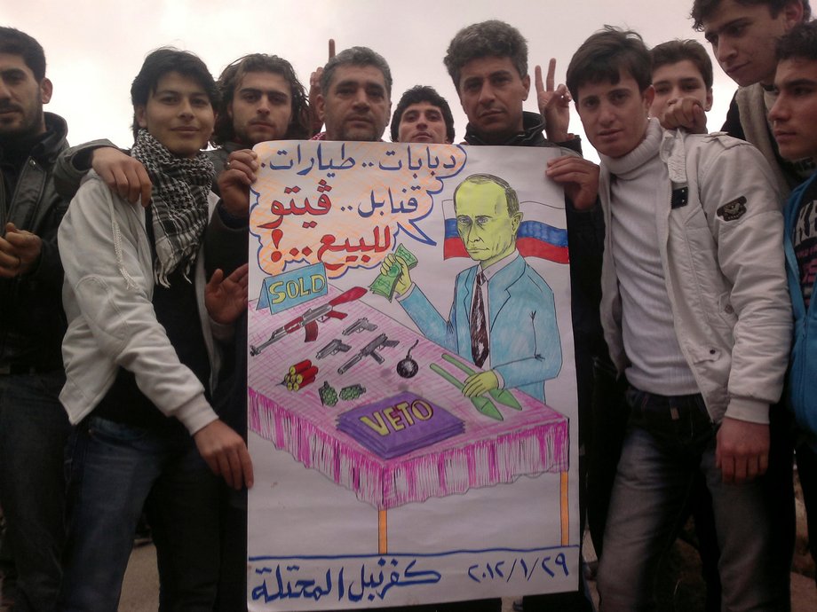 Demonstrators hold a sign as they gather during a protest against Syria's President Bashar al-Assad and Russia in Kafranbel, near Idlib January 29, 2012.