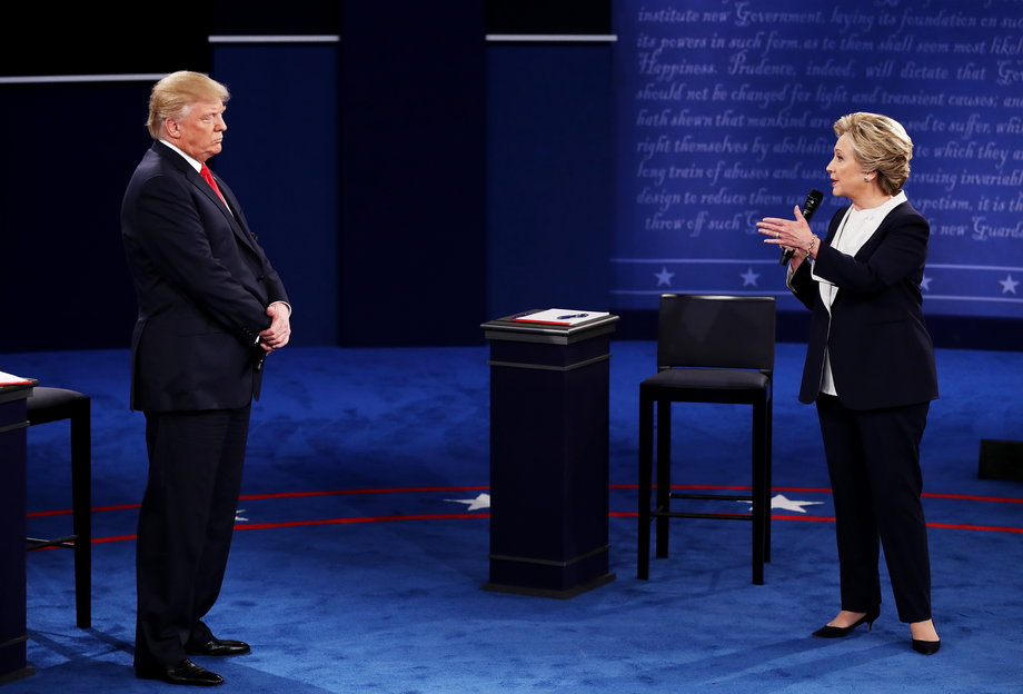Democratic presidential nominee former Secretary of State Hillary Clinton (R) speaks as Republican presidential nominee Donald Trump looks on during the town hall debate at Washington University on October 9, 2016 in St Louis, Missouri.