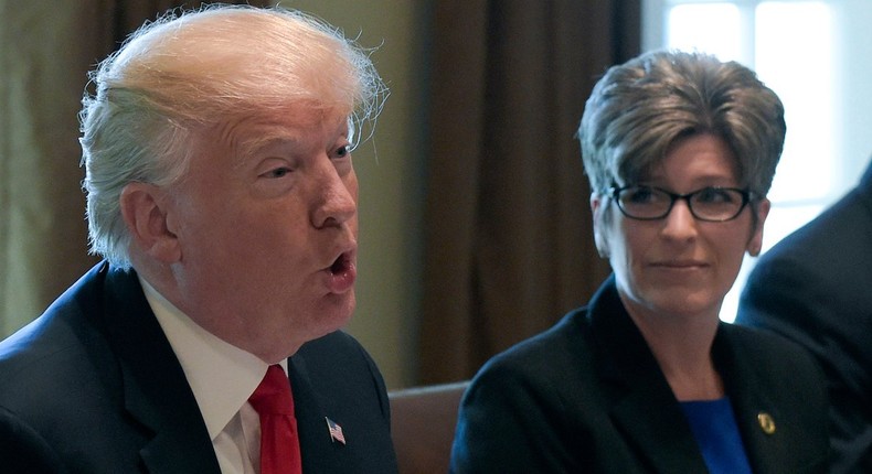 President Donald Trump speaks with Republican senators in the Cabinet Room of the White House as Sen. Joni Ernst listens.