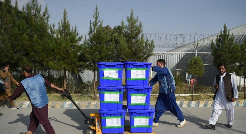 Independent Election Commission workers carry ballot boxes to a counting centre after the September poll