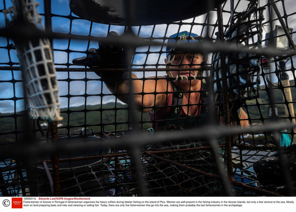 A fisherwoman removes the hook from a fish during the fishing