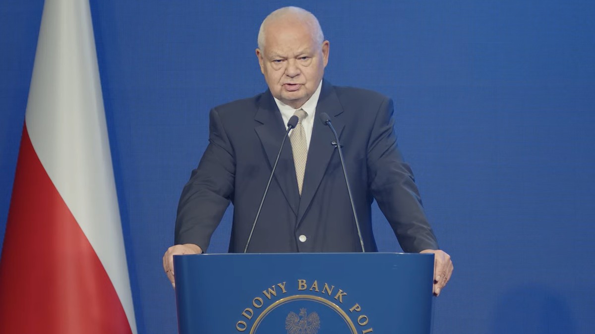 Adam Glapiński, prezes Narodowego Banku Polskiego, na tle flagi Polski.