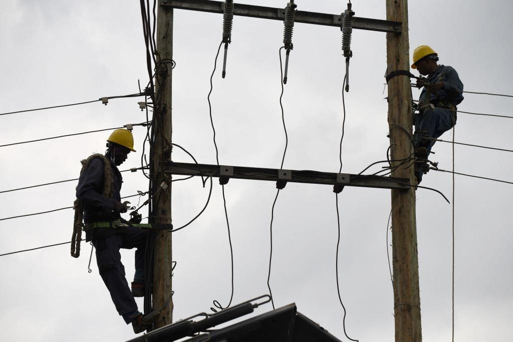 [FILE] Kenya Power and Lighting Company (KPLC) live line experts dismantle power cables to relocate power lines to pave way for the construction of the Nairobi Expressway in Westlands, Nairobi, on September 24, 2020. (Photo by SIMON MAINA/AFP via Getty Images)