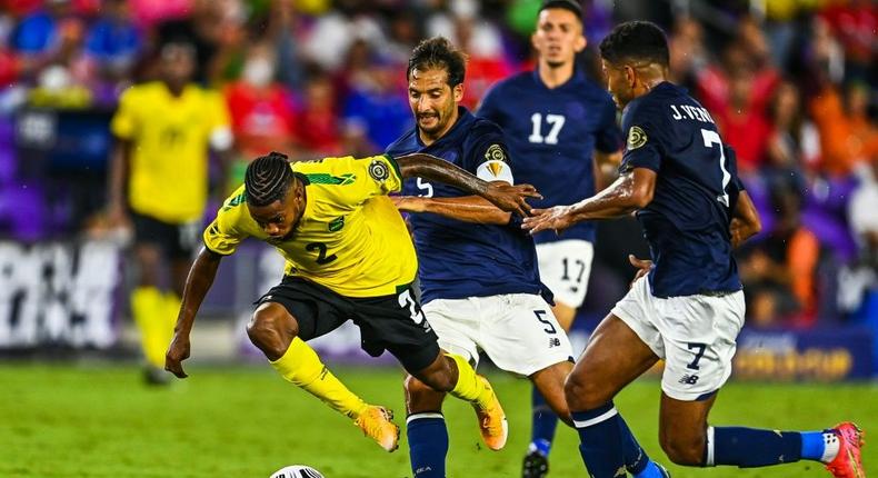 Jamaica's Lamar Walker (left) stumbles as he fights for the ball during the CONCACAF Gold Cup football match between Costa Rica and Jamaica in Orlando, Florida Creator: CHANDAN KHANNA