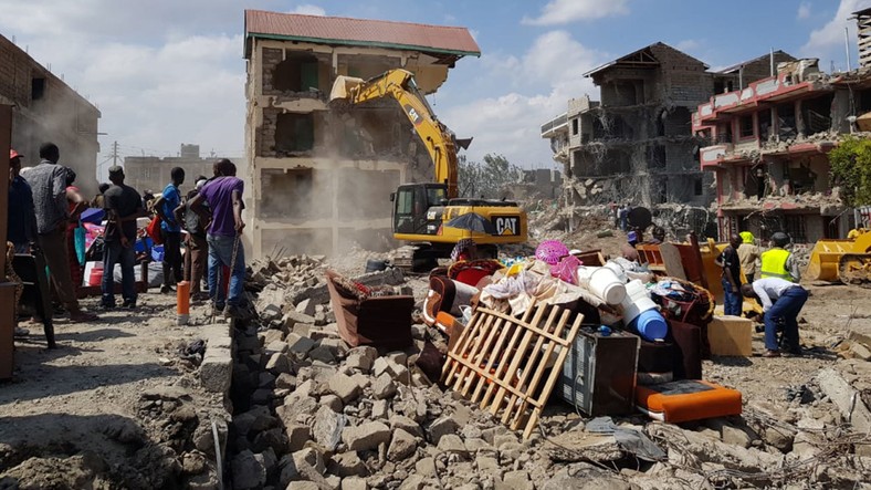 A bulldozer brings down a building Nyama Villa estate 