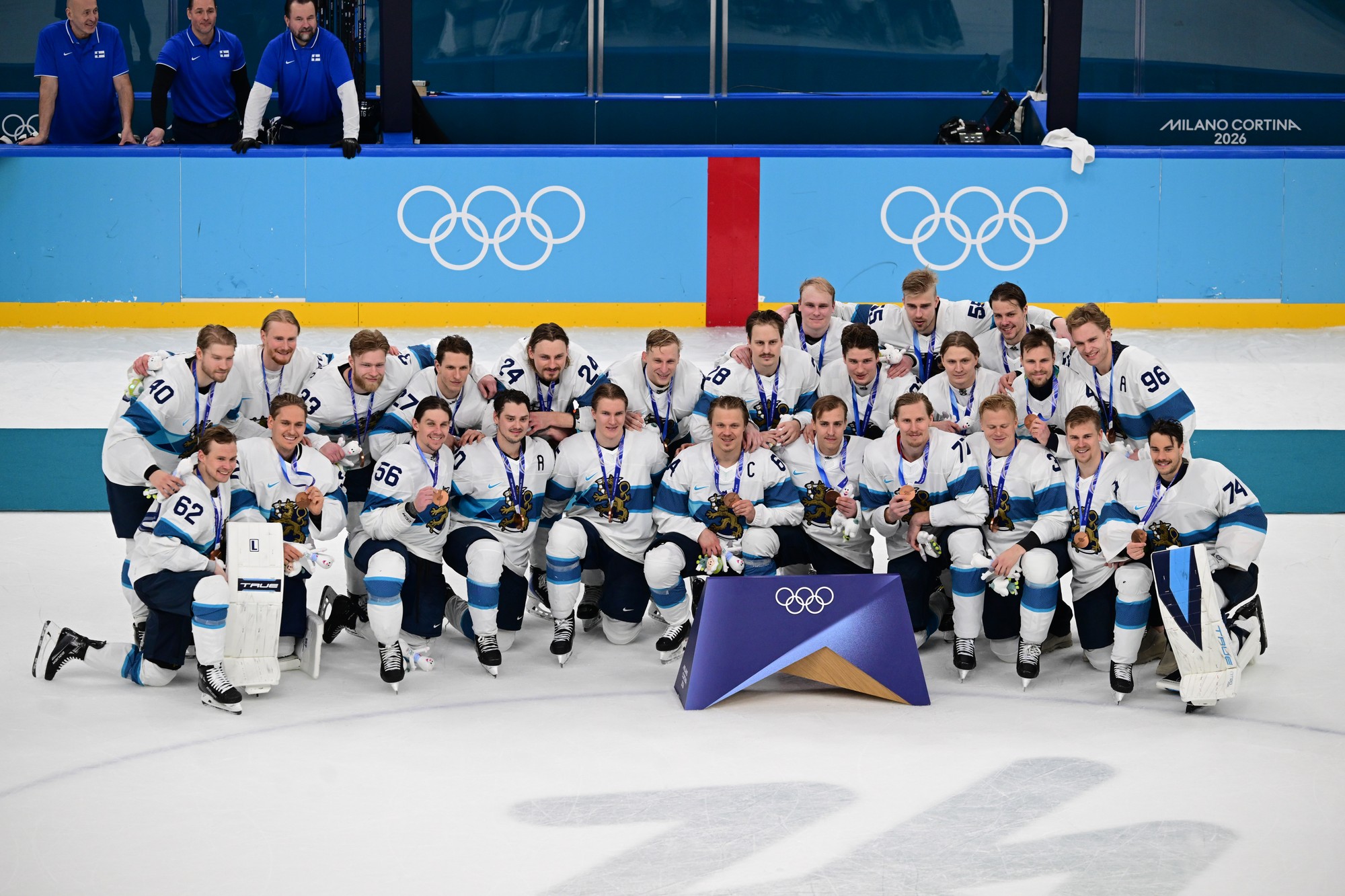 Fínski hokejisti pózujú s bronzovými medailami na ZOH 2026. 