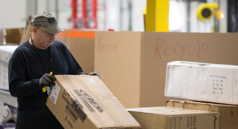 An Amazon worker sorts through incoming merchandise at the Amazon fulfillment center on February 13, 2015 in DuPont, Washington.