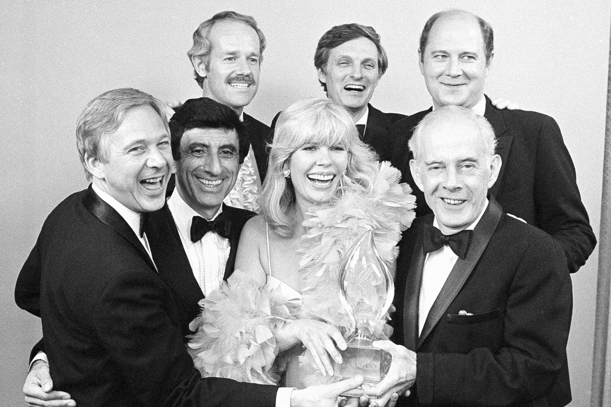 Herci zo seriálu M.A.S.H. : zľava William Christopher, Jamie Farr, Loretta Swit a Henry Morgan, zadný rad zľava, Mike Farrell, Alan Alda a William Ogden Stiers.
