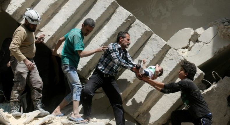 Syrian rescuers remove a baby from under rubble in al-Kalasa in northern Aleppo in April last year