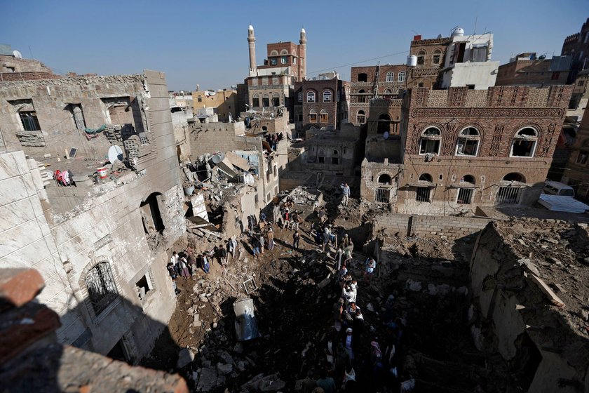 People gather at the site of an air strike in Sanaa, Yemen