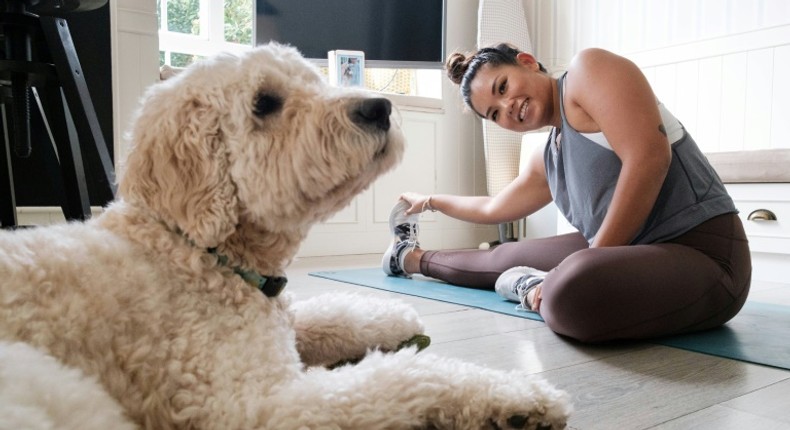 Singaporean Alison Yuen takes an online fitness class in her Hong Kong home, watched by her golden labradoodle Whelan