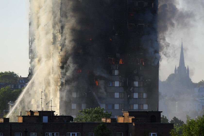 Flames and smoke billow as firefighters deal with a serious fire in a tower block at Latimer Road in