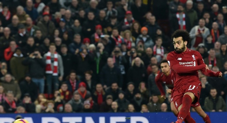 Liverpool's Egyptian midfielder Mohamed Salah (R) shoots to score their second goal from the penalty spot during the English Premier League football match between Liverpool and Newcastle United at Anfield in Liverpool, north west England on December 26, 2018.