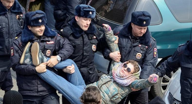 Police officers detain an opposition supporter during a rally in Vladivostok, Russia