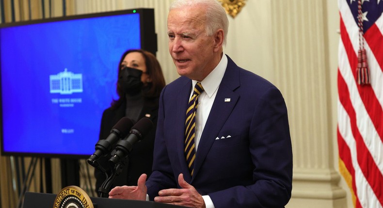 President Joe Biden speaks as Vice President Kamala Harris looks on during an event on economic crisis in the State Dining Room of the White House January 22, 2021 in Washington, DC.