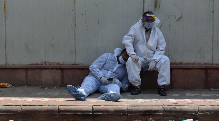 Holtfáradt egészségügyi dolgozók egy kórház mellett Új-Delhiben / EPA/IDREES MOHAMMED