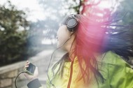 Young woman, outdoors, listening to music and dancing