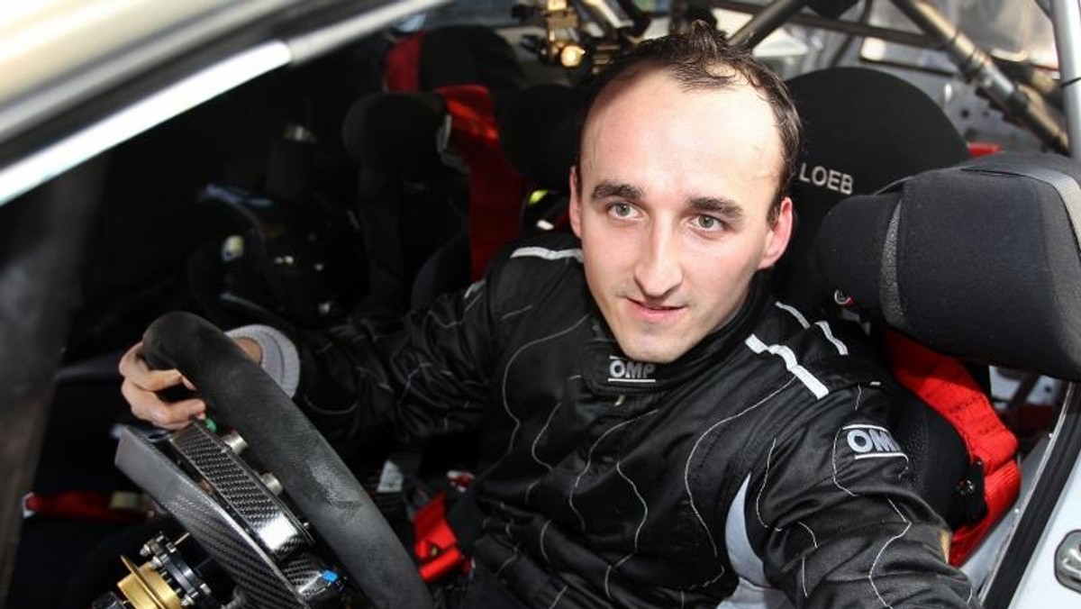 Robert Kubica za kierownicą samochodu rajdowego drzwi otwarte