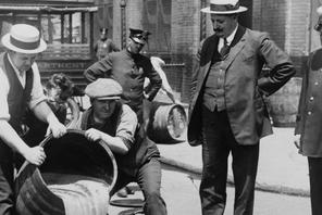 Prohibition in the USA 1920-1933: A barrel of confiscated illegal beer being poured down a drain. Al