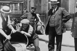 Prohibition in the USA 1920-1933: A barrel of confiscated illegal beer being poured down a drain. Al