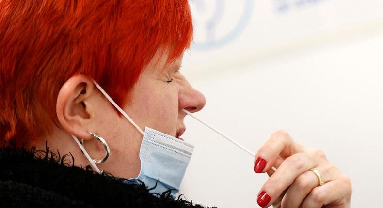 A woman uses a swab to take a sample from her nostril on May 25, 2021.

