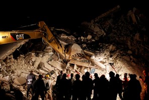 Rescuers work in the night at a collapsed house following an earthquake in Pescara del Tronto