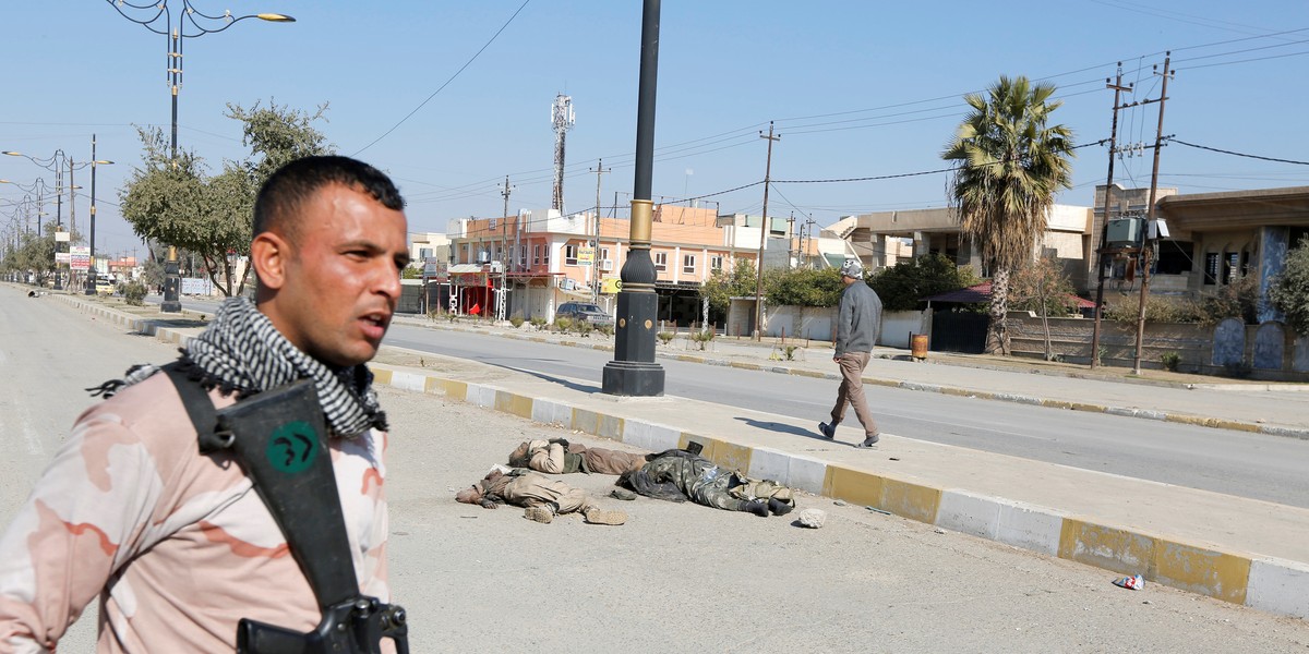 An Iraqi soldier with his weapon near corpses of ISIS militants killed in clashes in Mosul, February 6, 2017.