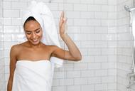 Young woman in white towels wrapped around head and body after shower
