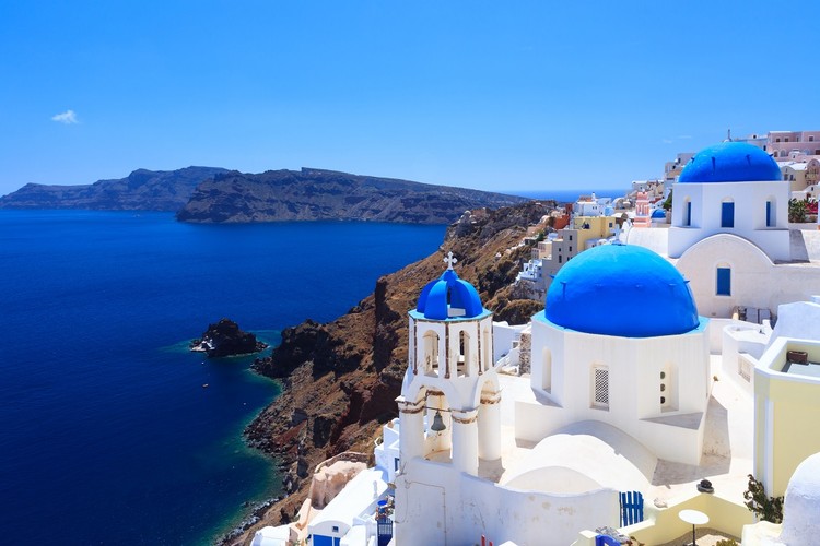 <strong>Santorini</strong>
<br></br>
UNESCO okrzyknęło Santorini najpiękniejszą wyspą na świecie. Chyba słusznie, bo to prawdziwa perła wśród wysp. Jej charakterystyczne czerwone klify tworzą wprost magiczne otoczenie. A wypełniona wodami morza egejskiego kaldera, która powstała ponad trzy i pół tysiąca lat temu wskutek wybuchu wulkanu, to widok, który niezmiennie zachwyca każdego kto tu przybywa. 
<br></br>
Dopełnieniem uroku tego miejsca są białe, tradycyjne domy pokryte błękitnymi dachami, które cudownie kontrastują z lazurowymi wodami i ciemnym wybrzeżem. W przeciwieństwie bowiem do pozostałej części Grecji, tutejsze plaże nie są białe. 
<br></br>
– Nie oznacza to jednak, że są gorsze. Wręcz przeciwnie. Czarny piasek dodaje im wyjątkowego charakteru, a słynąca z niego Kamari to jedna z najpopularniejszych plaż na całych Cykladach – zauważa Piotr Wilk z biura podróży Rainbow. 
<br></br>
Jedno jest pewne, trudno o scenerię bardziej romantyczną i unikalną. Wulkaniczny krajobraz można tu podziwiać z różnych perspektyw – opalając się na plaży, siedząc na tarasie jednej z wielu kameralnych knajpek, lub też przemierzając jeden z wielu szlaków spacerowych wokół wyspy. Wymarzone miejsce na wakacje, nie tylko we dwoje. 
<br></br>
<a  href=