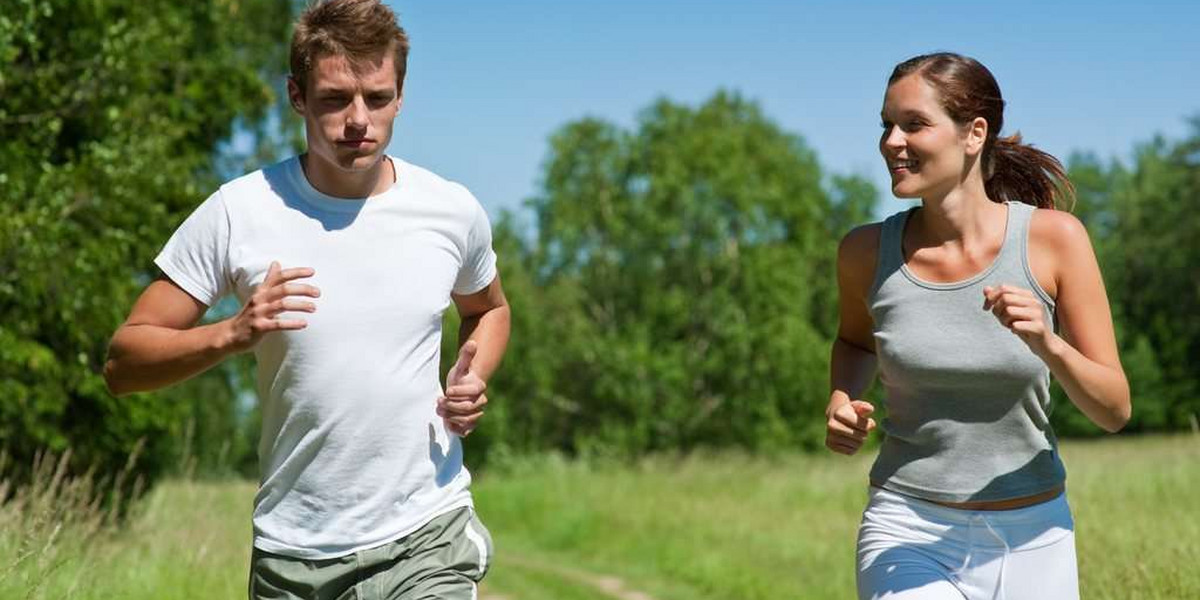 Sportive man and woman jogging outdoors