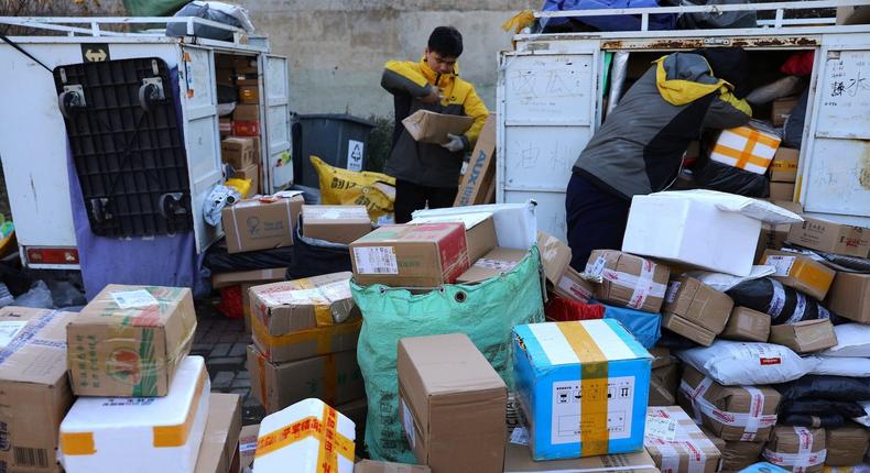 Delivery workers sort parcels at a makeshift logistics station in Beijing, China.