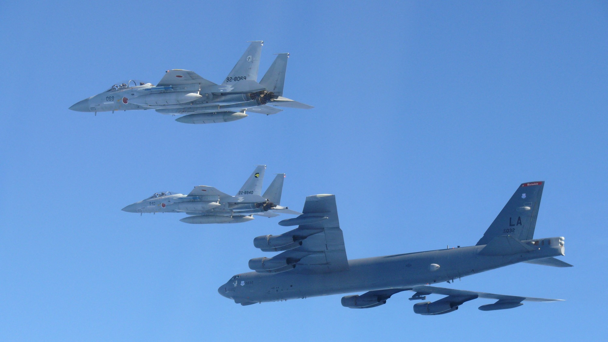 Fotografia ukazuje ako stíhačky F-15 japonských vzdušných síl sebaobrany absolvujú spoločné vojenské cvičenie s americkým bombardérom B-52 nad Japonským morom