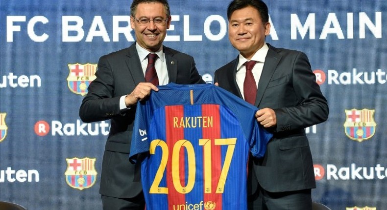 Barcelona's president Josep Maria Bartomeu (left) and CEO of Japanese company Rakuten Hiroshi Mikitani display the new team jersey after signing an agreement in Barcelona on November 16, 2016