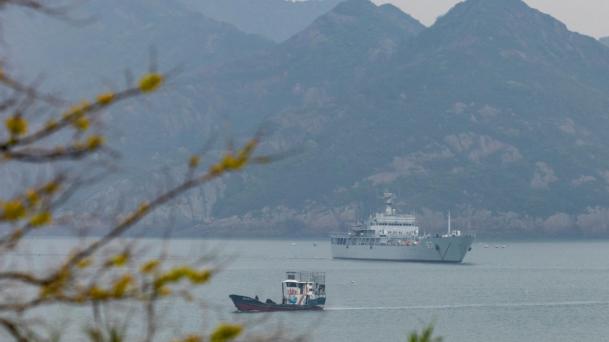 Čínska bojová loď na vojenských cvičeniach, v pozadí taiwanské súostrovie Ma-cu.