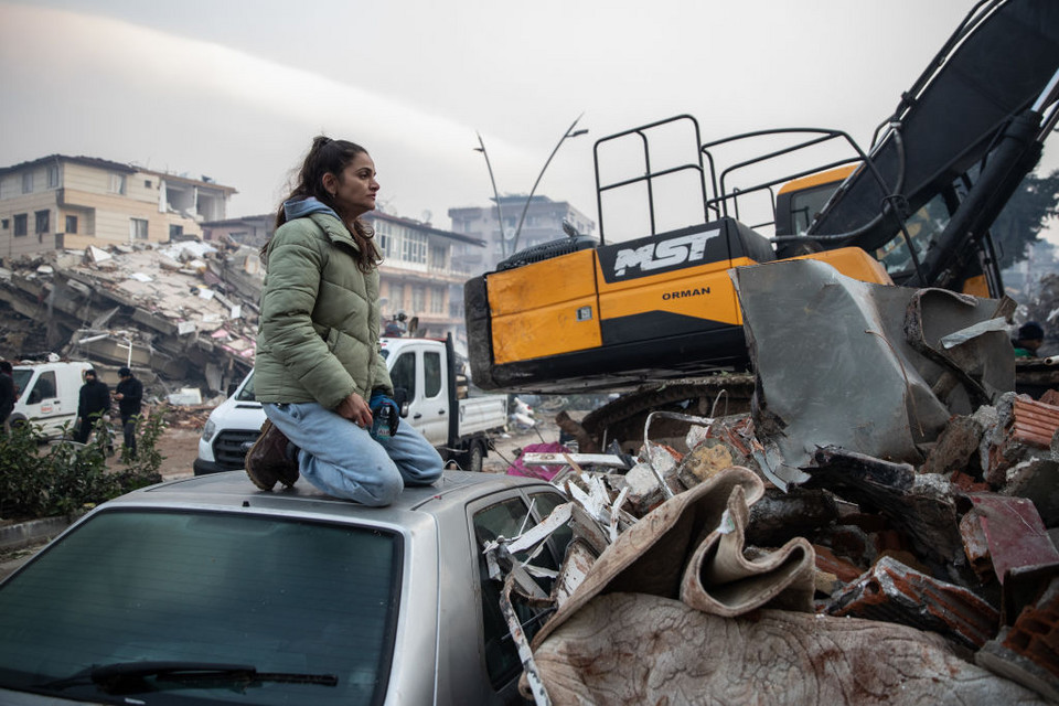 Kobieta z nadzieją czekająca na wieści o odnalezieniu jej bliskich pod gruzami w Turcji