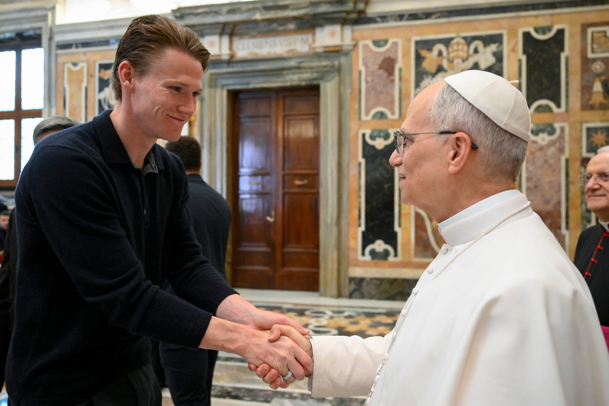 Stredopoliar neapolského futbalového tímu Scott McTominay (vľavo) si podáva ruku s pápežom Levom XIV. počas súkromnej audiencie s tímom vo Vatikáne.