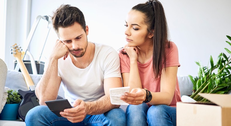 Concerned homebuyers looking over bills.Getty Images