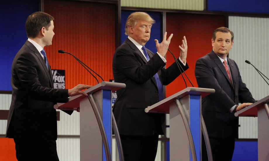 Republican presidential candidate Donald Trump shows off the size of his hands as rivals Marco Rubio, left, and Ted Cruz, right, look on at the start of the Republican presidential-candidate debate in Detroit, Michigan, March 3, 2016.