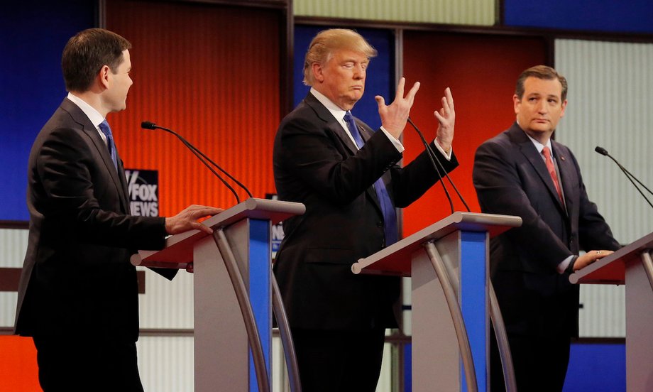 Republican presidential candidate Donald Trump shows off the size of his hands as rivals Marco Rubio, left, and Ted Cruz, right, look on at the start of the Republican presidential-candidate debate in Detroit, Michigan, March 3, 2016.