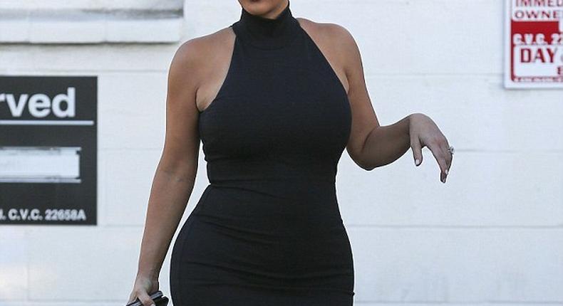 Kim Kardashian shows off baby bump in skintight black dress