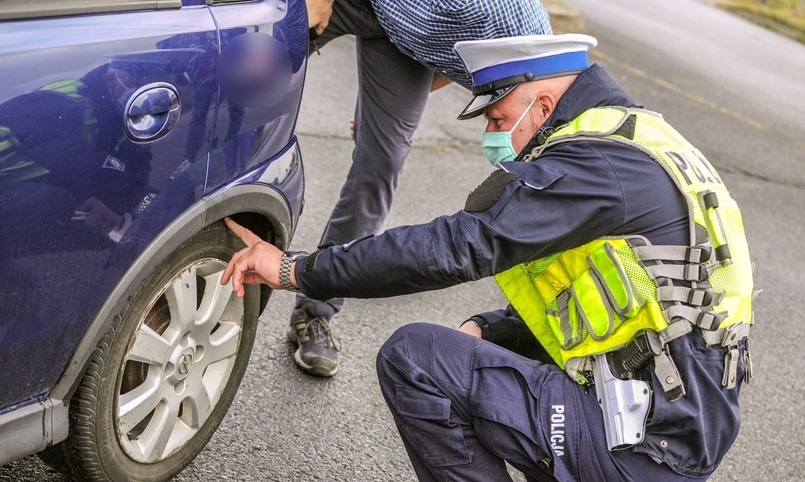 Policjant kontroluje stan opon