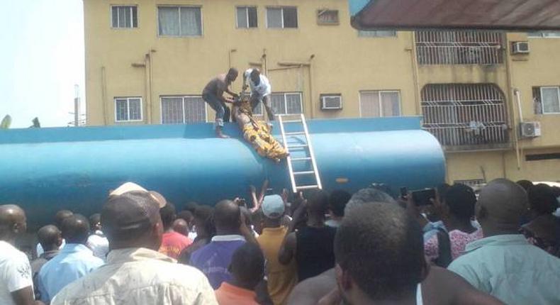 Two men are seen bringing out the corpse of Emmanuel from the petrol tanker.