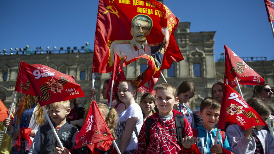 Dzieci należące do Pionierów, stoją na Placu Czerwonym z flagą z portretem Józefa Stalina