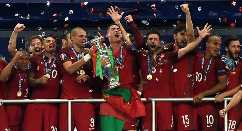 (From R) Portugal's midfielder Adrien Silva, Portugal's midfielder Joao Mario, Portugal's midfielder Andre Gomes, Portugal's midfielder Joao Moutinho, Portugal's forward Cristiano Ronaldo, Portugal's defender Pepe, Portugal's forward Ricardo Quaresma and Portugal's defender Bruno Alves pose with the trophy as they celebrate after beating France during the Euro 2016 final football match at the Stade de France in Saint-Denis, north of Paris, on July 10, 2016.