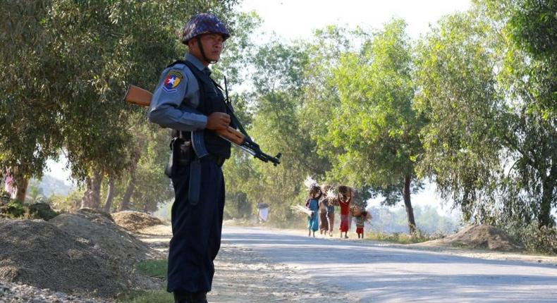 An armed Myanmar policeman stands guard on a road in northern Rakhine State from where tens of thousands of Rohingya have fled to Bangladesh to escape persecution