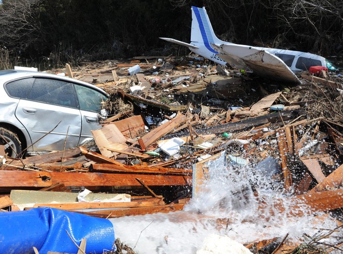 Lekki samolot i samochód w gruzowisku na zdewastowanym lotnisku w Sendai