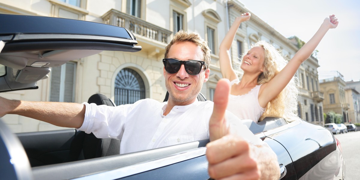 Car driver happy giving thumbs up - driving couple