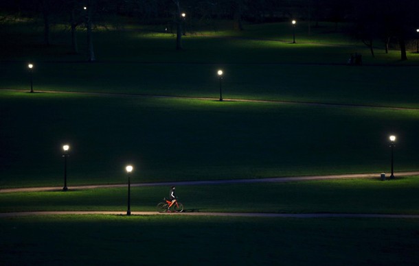 A cyclist rides through Primrose Hill in the early evening in London