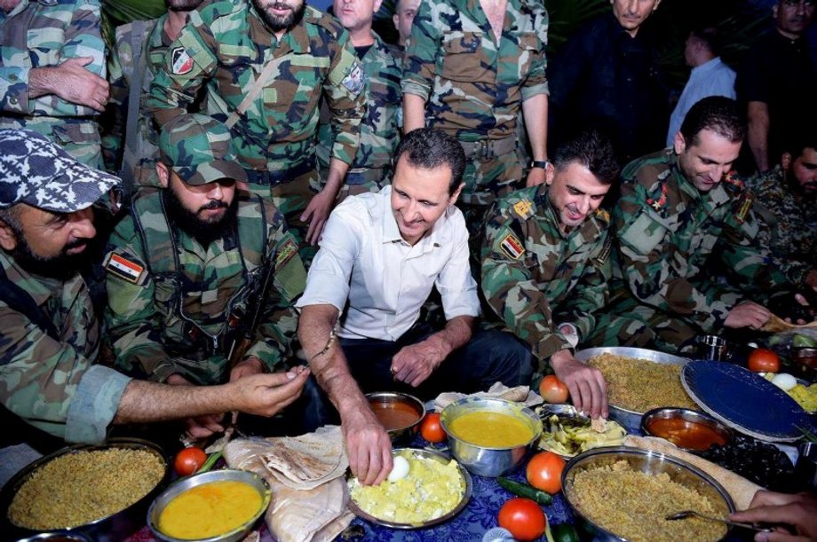 Syria's President Bashar Assad joins Syrian army soldiers for Iftar in the farms of Marj al-Sultan village.